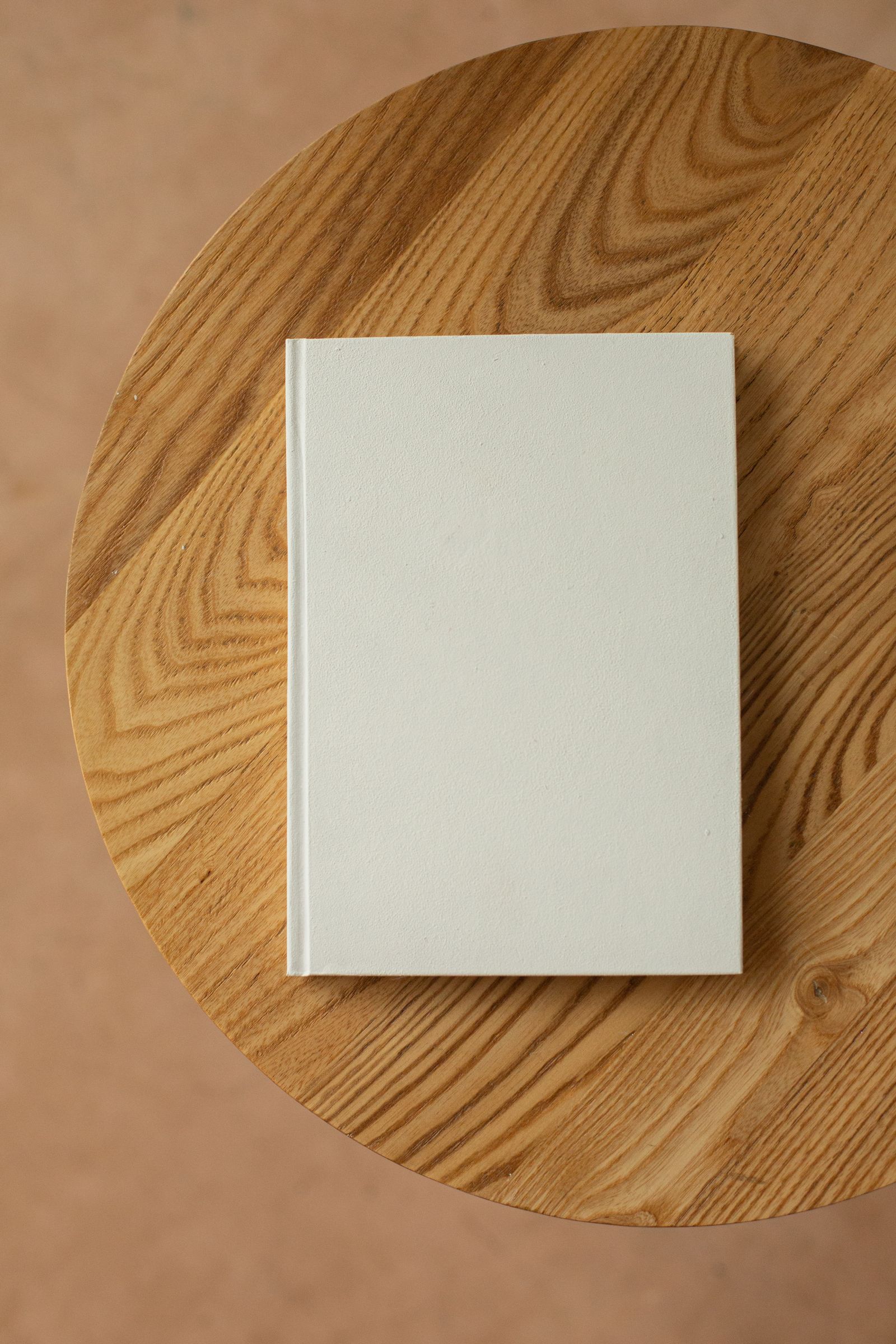 A blank editorial journal on a wooden studio table — the empty page every content week starts with.
